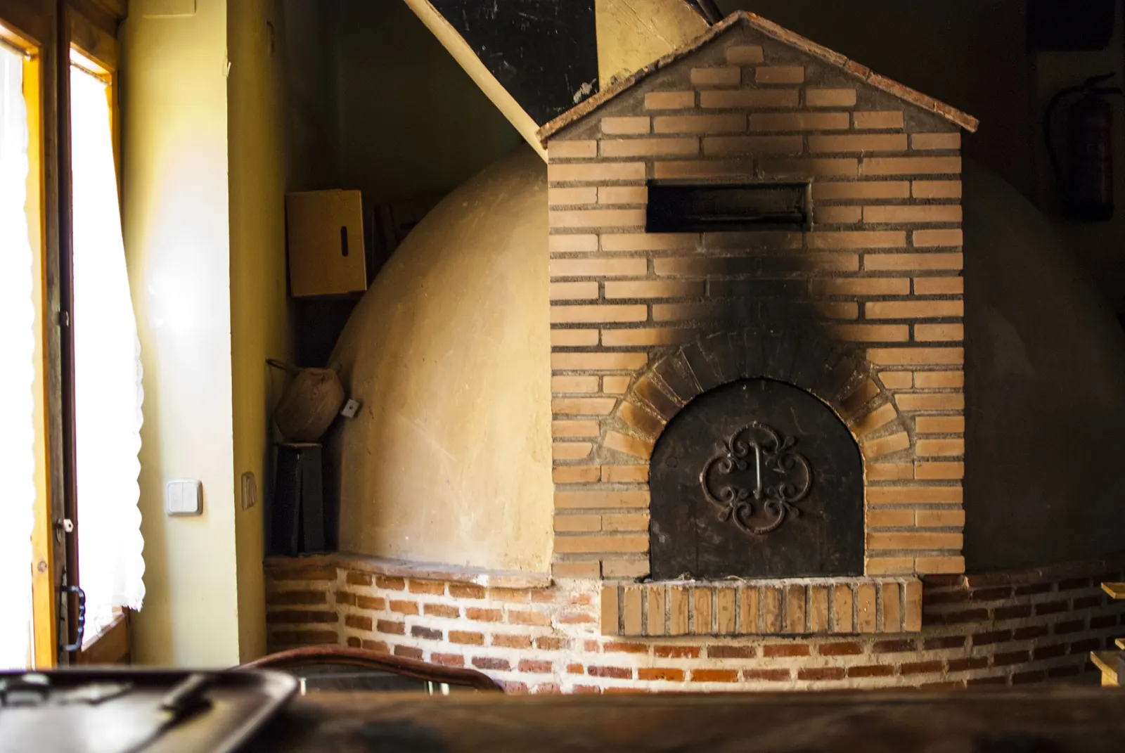 Horno de leña de ladrillo y barro con su puerta de hierro forjado